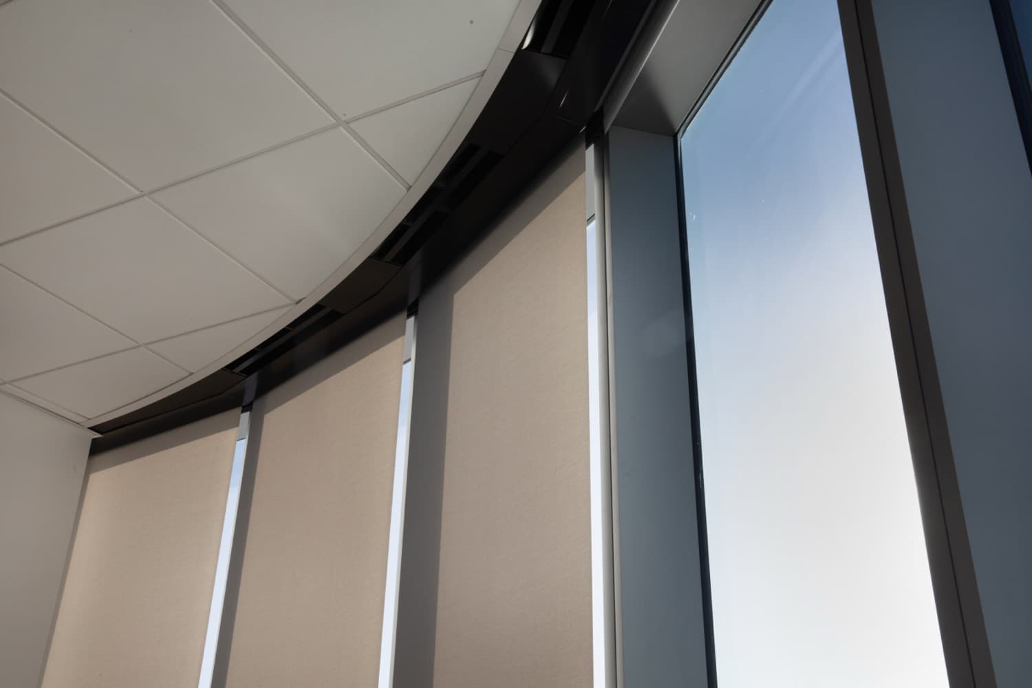 FIS World Headquarters — motorized roller shades pocketed along the curved curtain-wall glazing