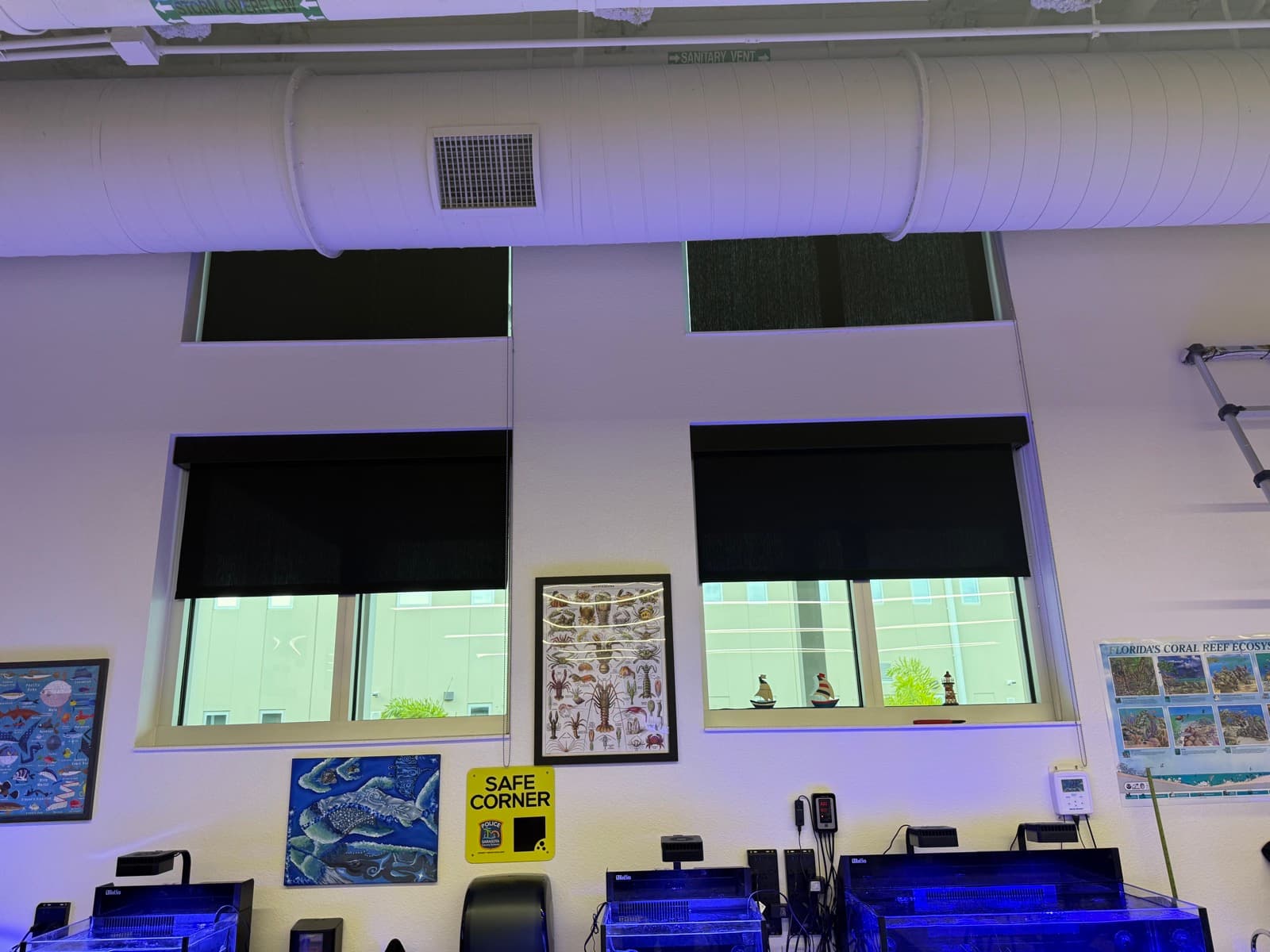 Wellen Park High School — marine-science classroom with roller shades over the aquarium bays, Sarasota, FL